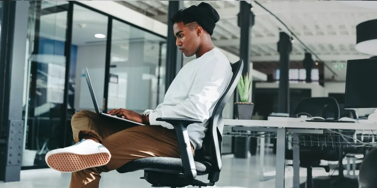 A developer using JavaScript classes at their laptop in an office.