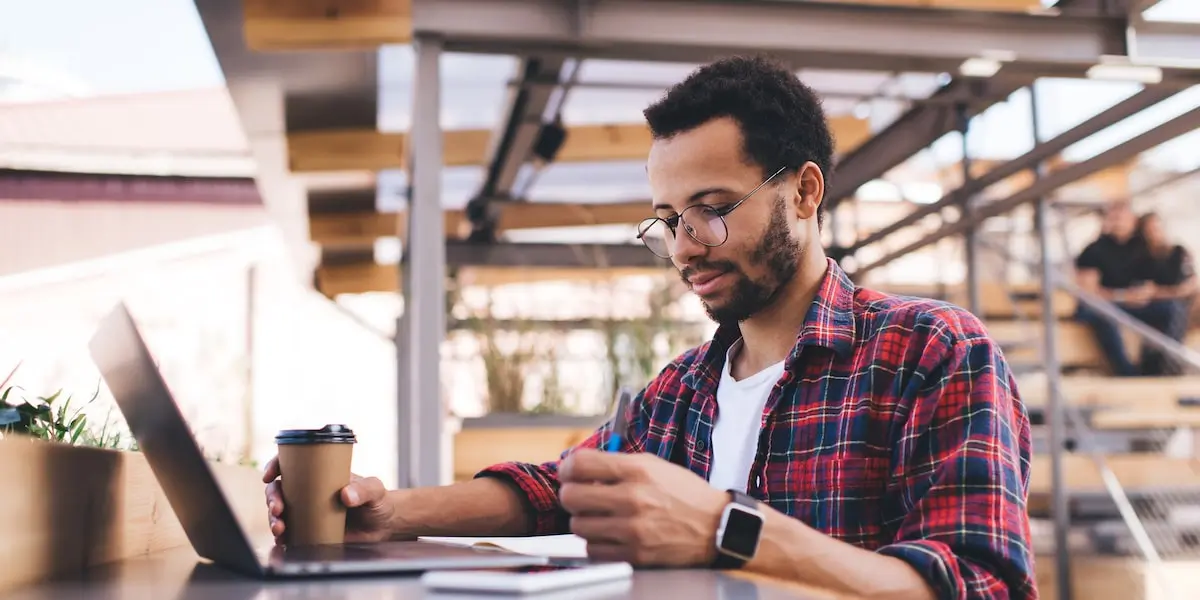 Man working on one of the free courses on social media marketing while at a cafe.