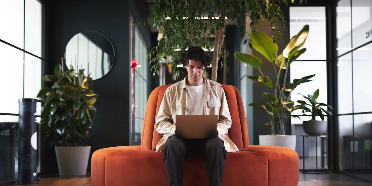 Man works remotely with his laptop working in a recession-proof industry.