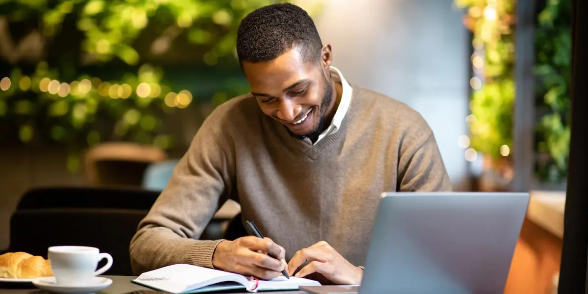 Man sitting in cafe with laptop taking a software engineering course.