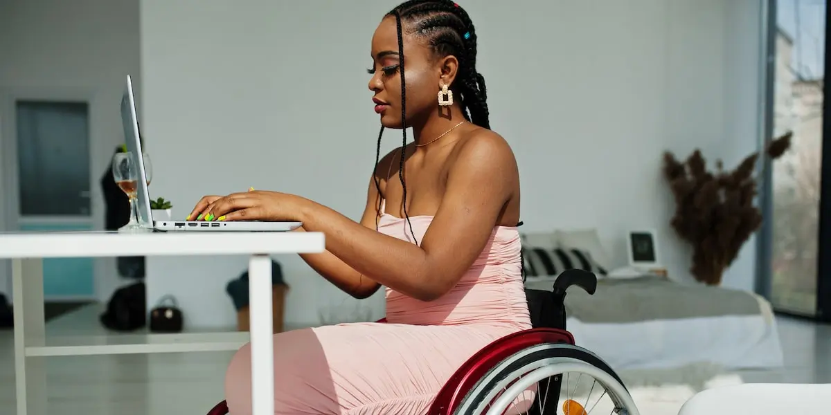 A developer in a wheelchair working from home sets up AWS IAM access for their company.