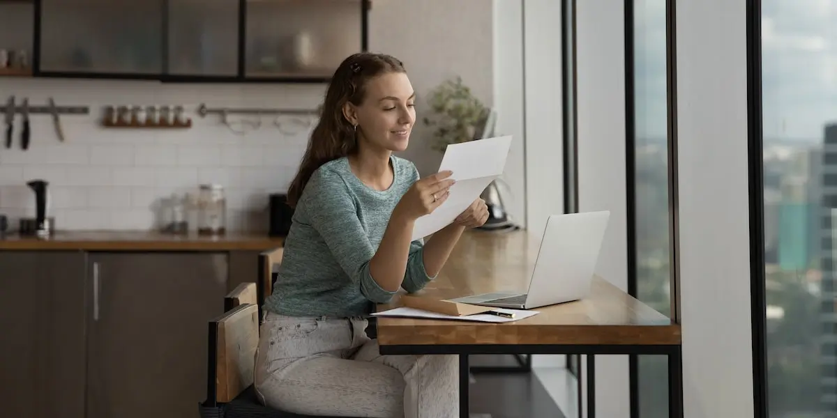 a certified coding bootcamp can mean it has a great reputation A woman sits with her laptop holding a certificate from her coding bootcamp.