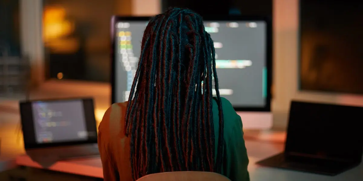 backend developers use a wide array of tools A backend developer sits in a home office looking at two screens of code.