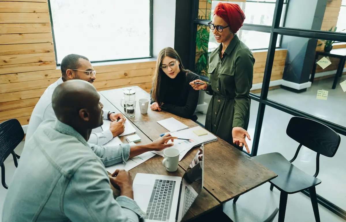A cloud engineer teaches her colleagues in an office about AWS S3 security.