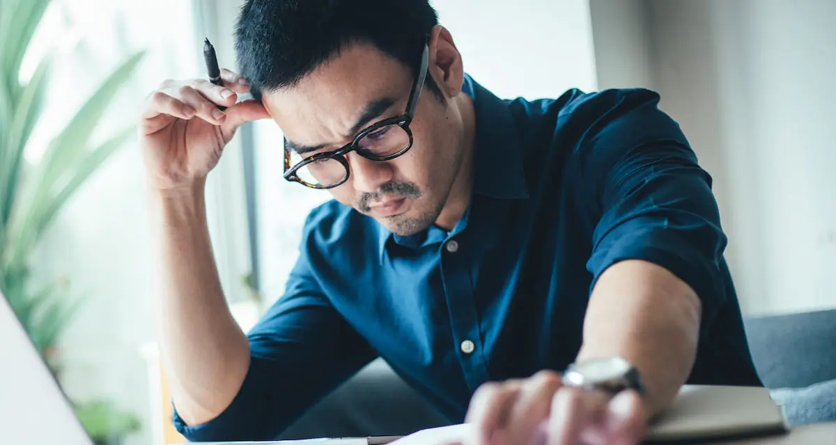 Young office employee thinks "I hate my job" while working at his desk.