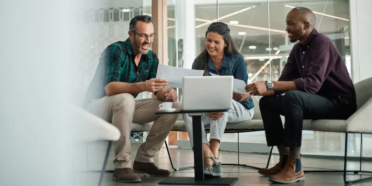 An entry-level product manager discussing something with their team in an office.