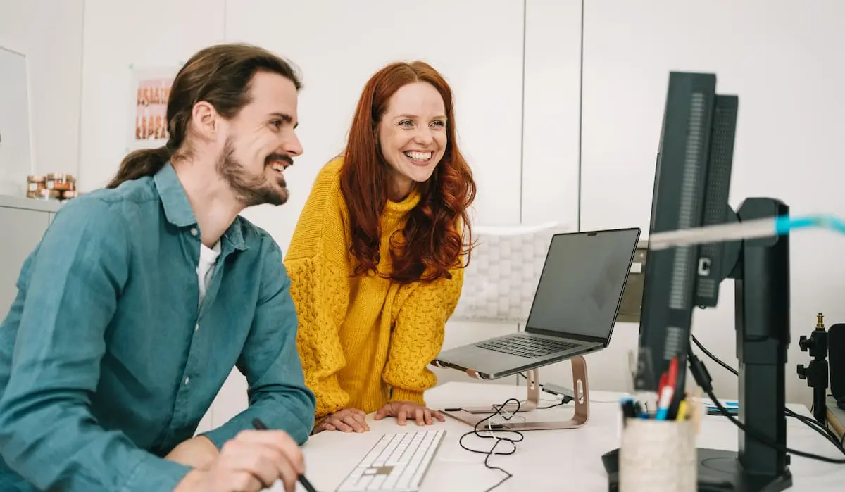 Two data product managers working together at a desk in an office.