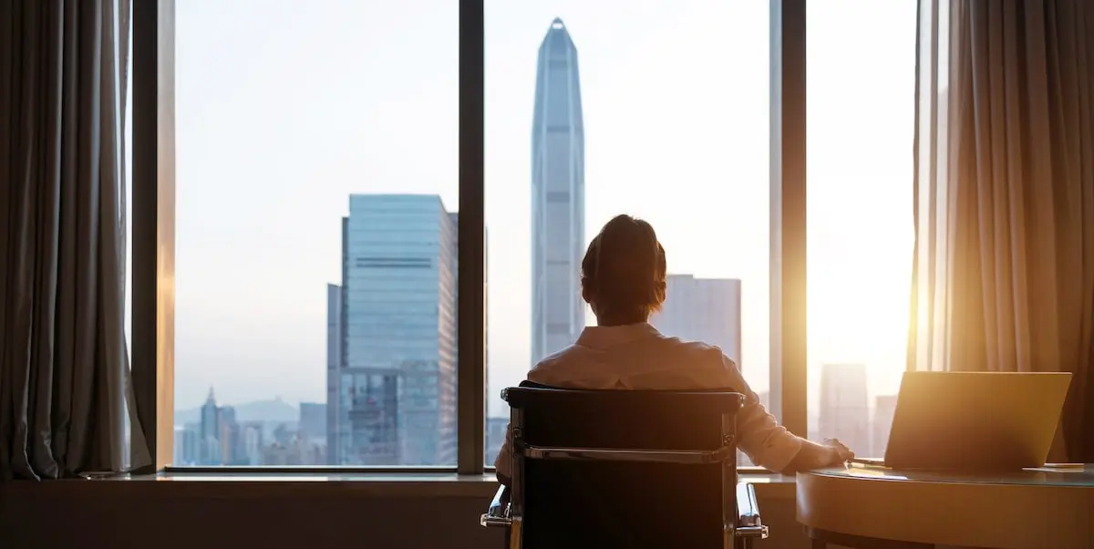 A woman taking an NYC coding bootcamp stops to look out her window at the city.