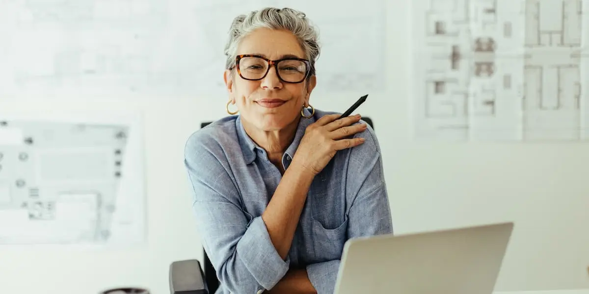 A senior graphic designer looks at the camera