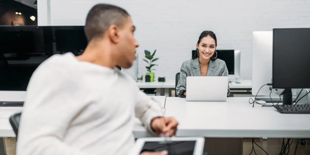 A woman earning a data scientist salary in Germany talks to her colleague in an office.