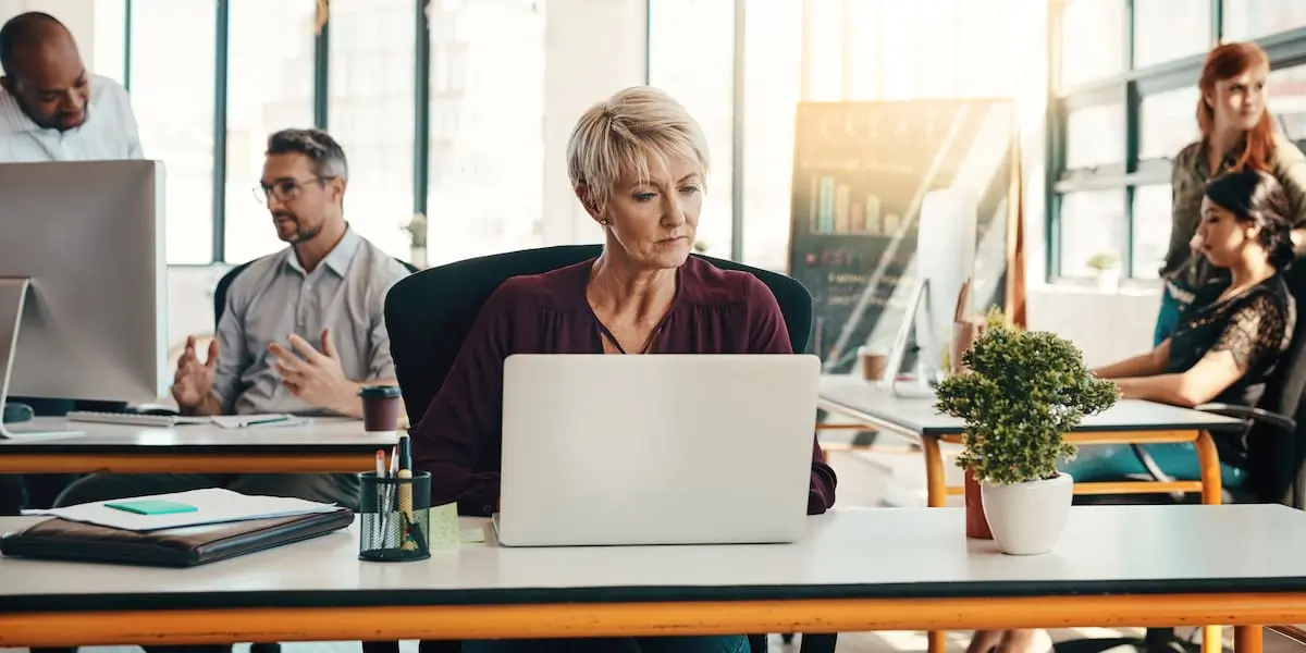 A product manager works in a bright office using AI tools.