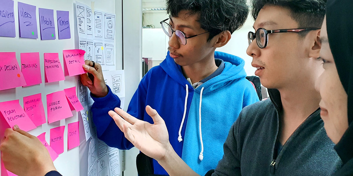 Affinity Mapping for Teams A team of designers gathered around their affinity map