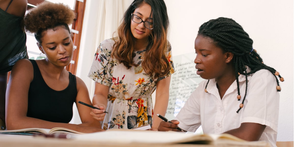 Three UX bootcamp students gathered at a table, working on a project
