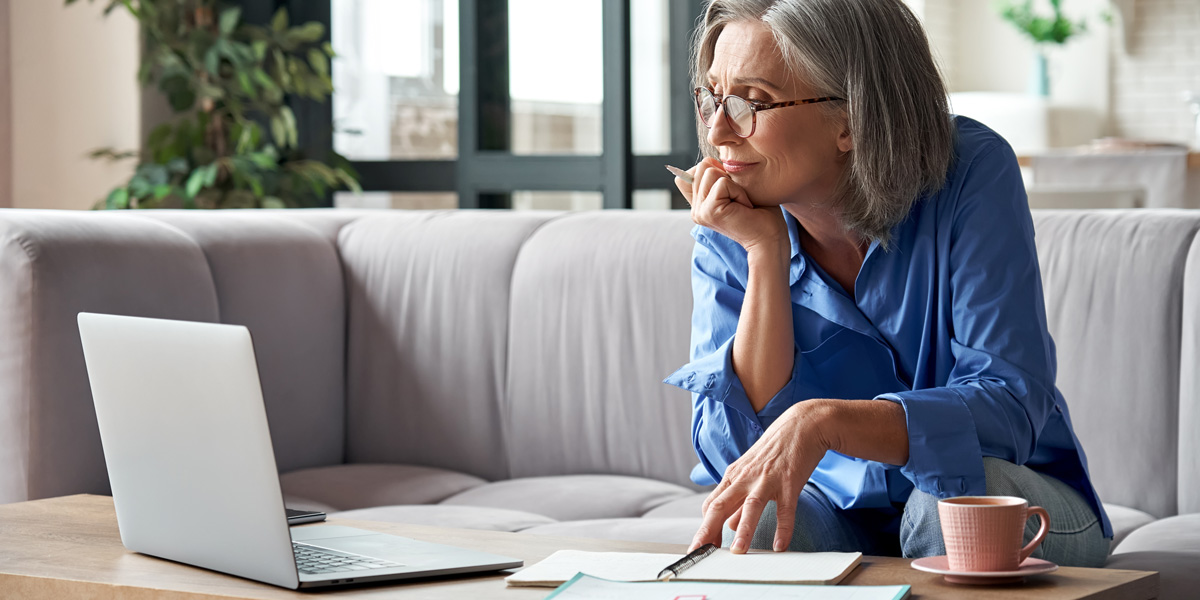 A teacher sitting at her coffee table, planning lessons and drinking tea