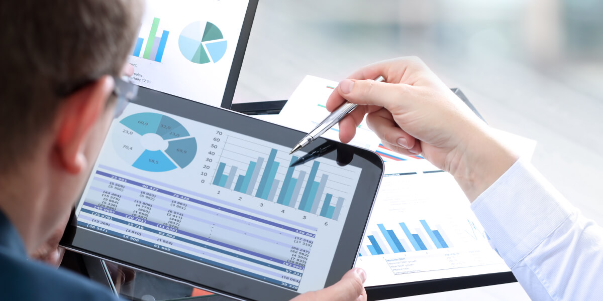 A data analyst looking at some graphs on a tablet A data analyst looking at some graphs on a tablet