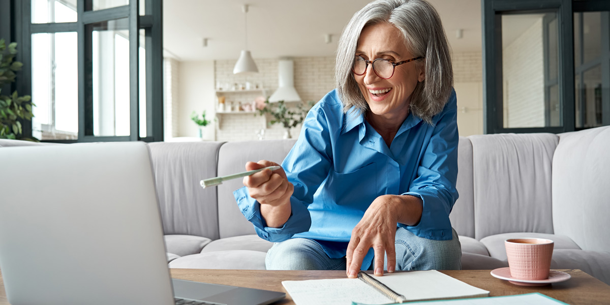 Am I Too Old for a Career in UX? A UX designer working from their couch, with a journal, laptop, and cup of coffee