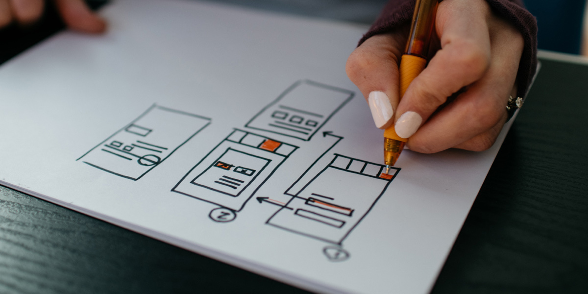 A digital designer wireframing on a piece of paper