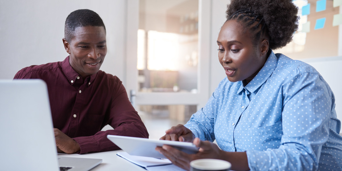 UX designers sitting at a desk, looking over portfolio elements