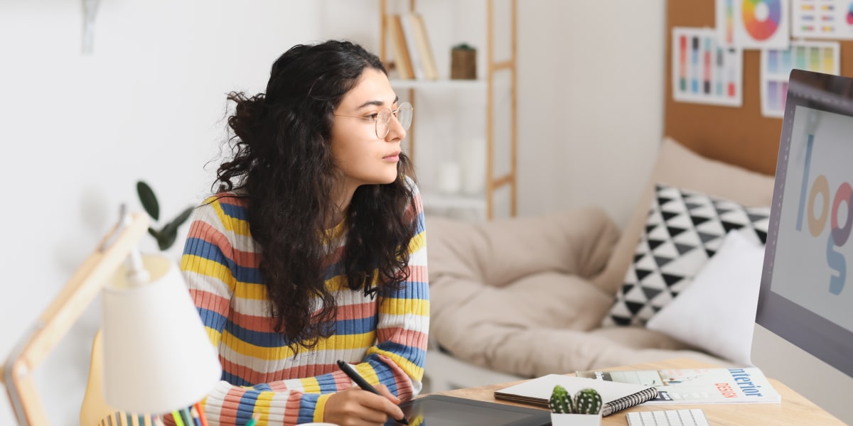 A user interface designer sitting at a desk, looking at a computer screen