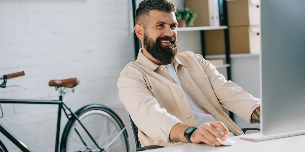 Man sitting at a desktop computer, working on tasks