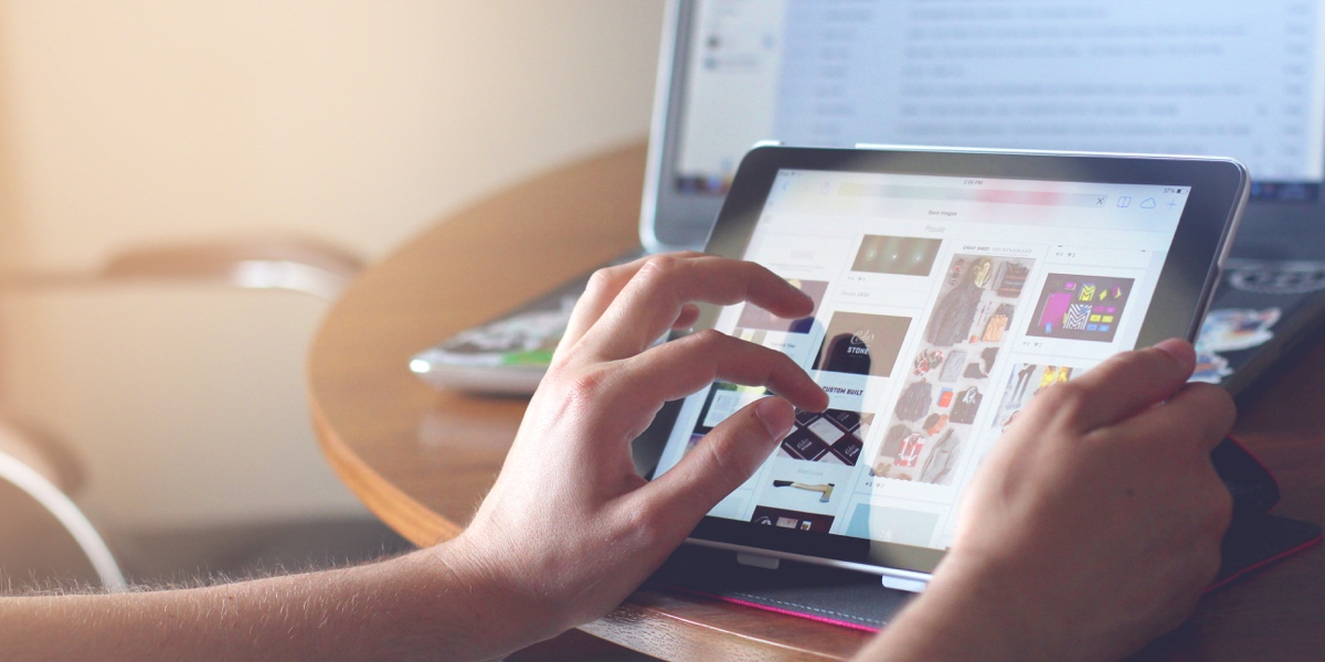 A user's hands, browsing images on a tablet
