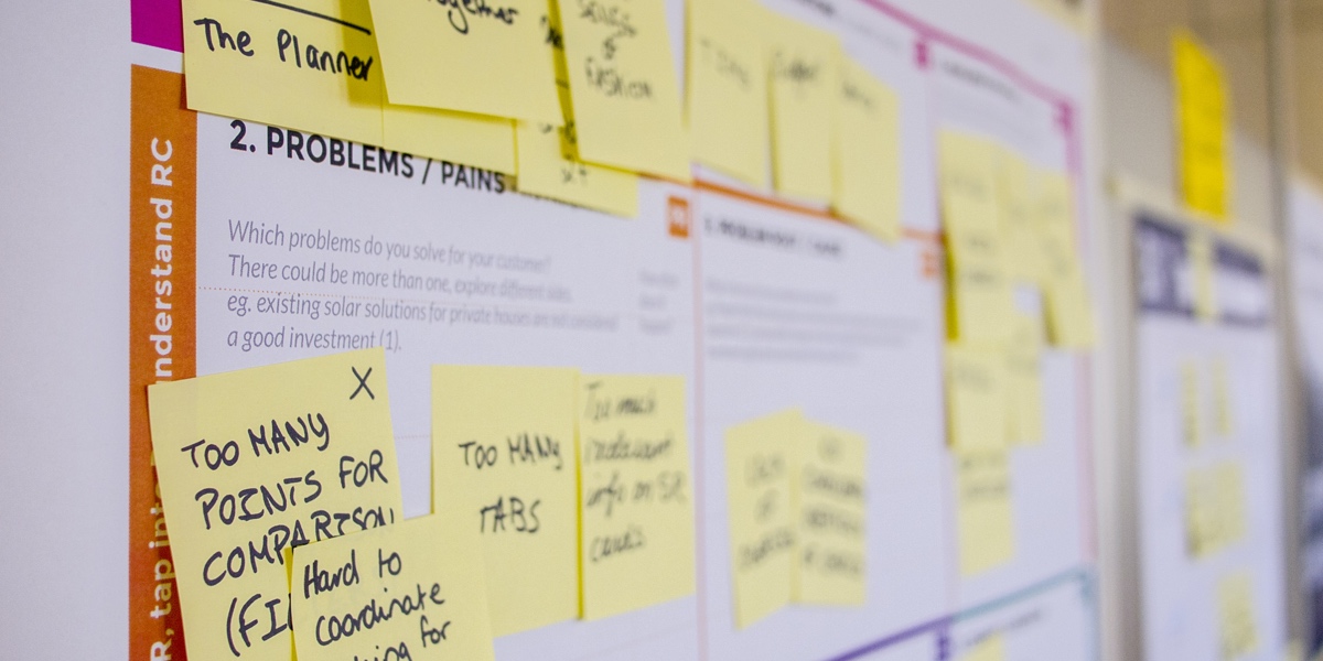 What's it like to be a UX researcher? Sticky notes all over a customer journey map on a wall, detailing user pain points