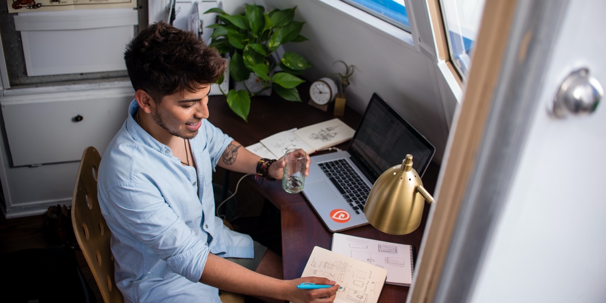 Qualitative vs. Quantitative UX Research A UX researcher working from home, near a window, looking over research plans