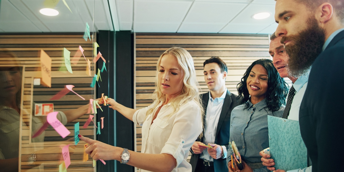 A group of designers and business people gathered around an idea board