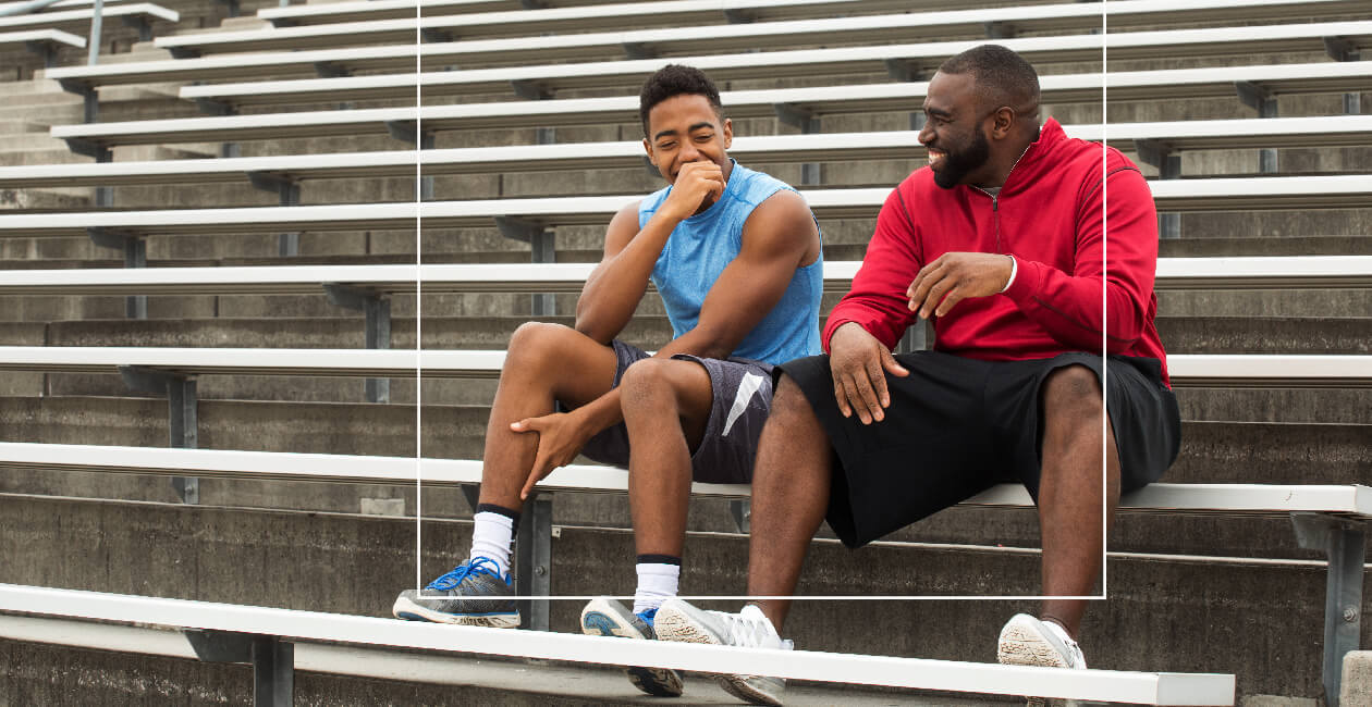 Two men sat on a step chatting with one another