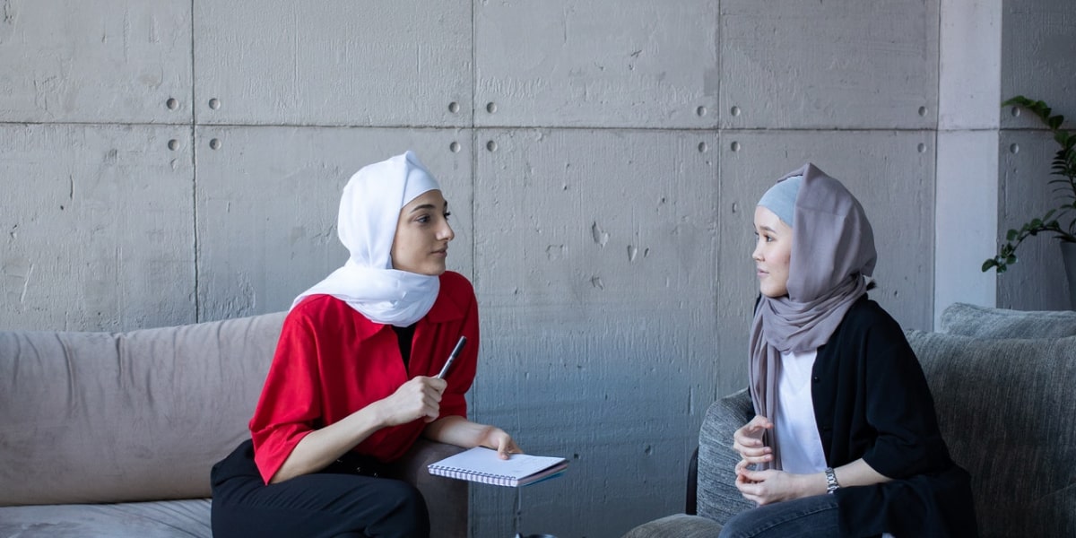 Two people sitting on couches in a startup office having a job interview.