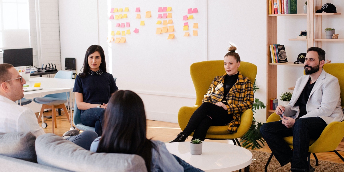 Group of designers seated around a coffee table, reflecting on a process in conversation